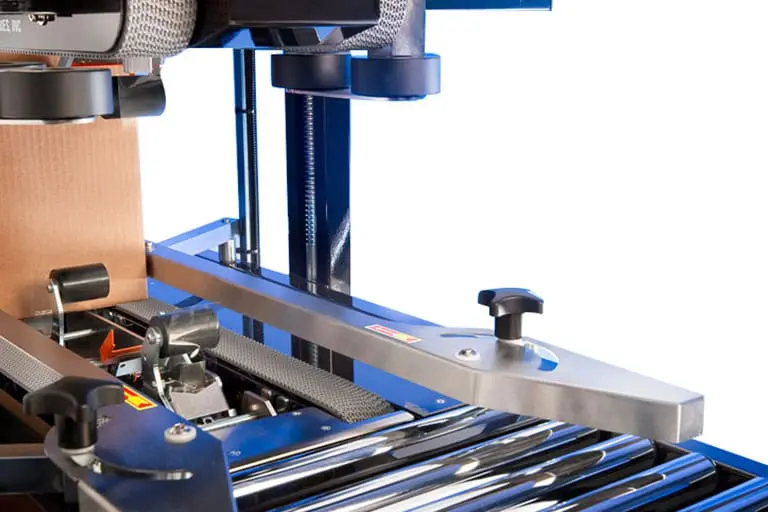 Packaging machine with conveyor and cardboard box.