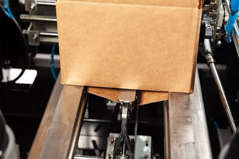 Cardboard box on automated packaging machine.