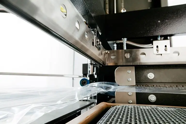 Industrial packaging machine with plastic film.