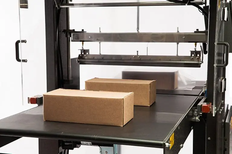 Two cardboard boxes on a conveyor belt.