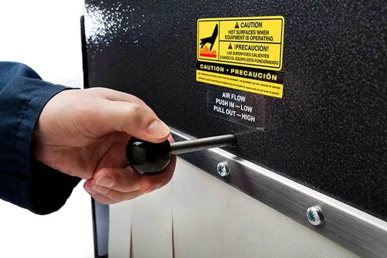 Hand adjusting lever on industrial machine.