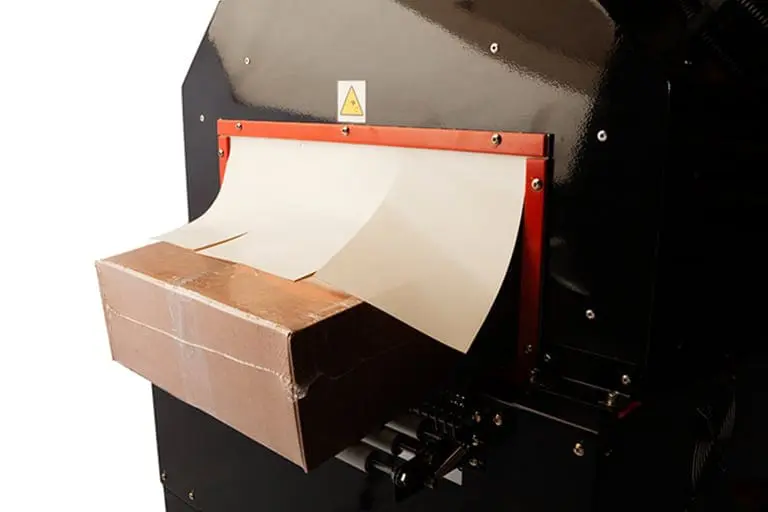 Cardboard box entering industrial shredding machine.