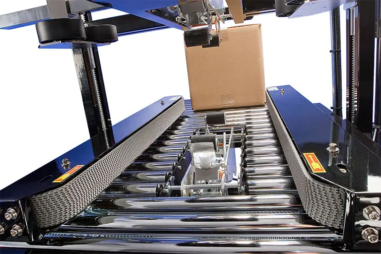 Packaging machine with conveyor and cardboard box.