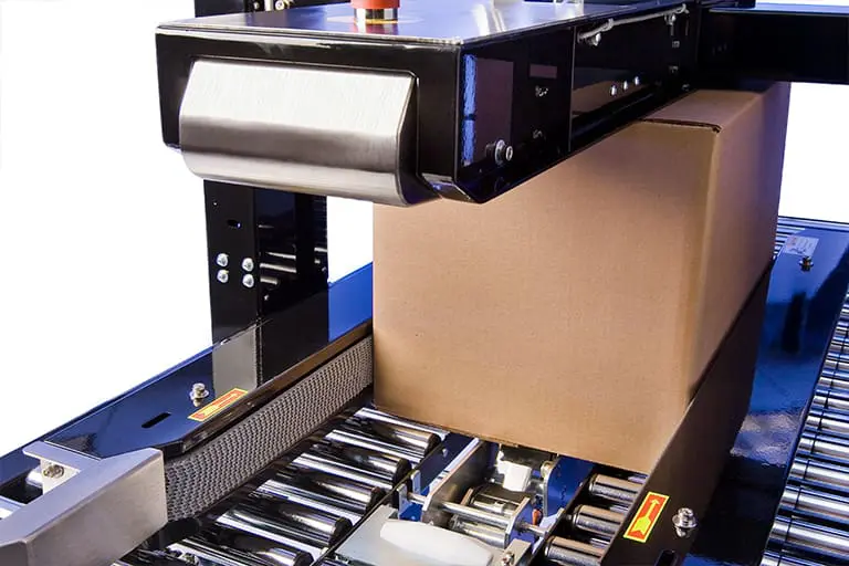 Machine sealing a cardboard box on conveyor.