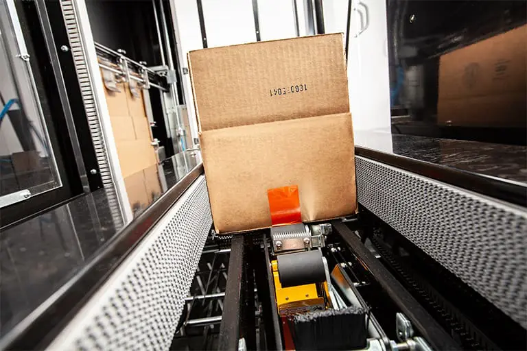 Cardboard box on automated conveyor belt.