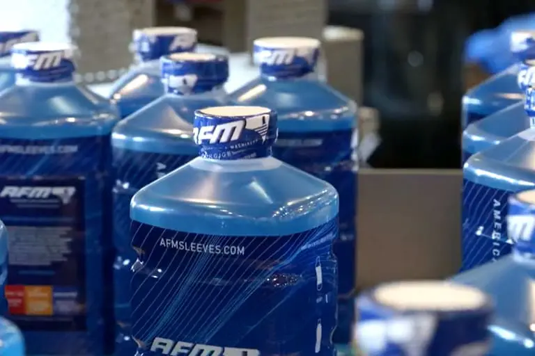 Blue liquid containers on assembly line.
