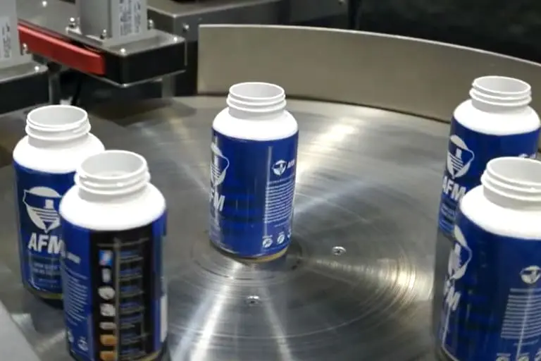 Bottles on a rotating industrial conveyor belt.
