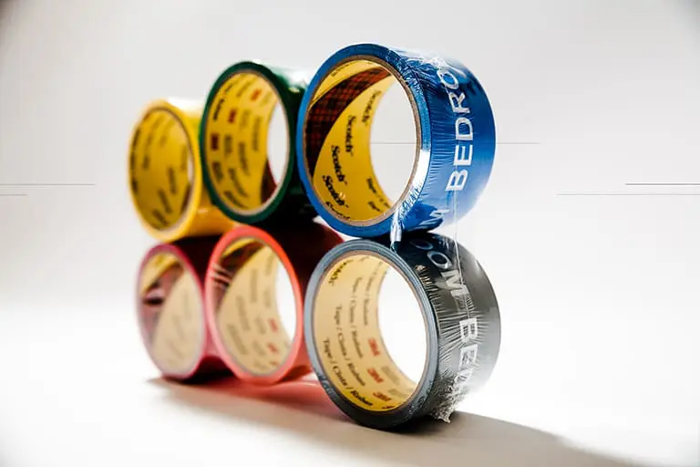 Six colorful rolls of adhesive tape stacked.