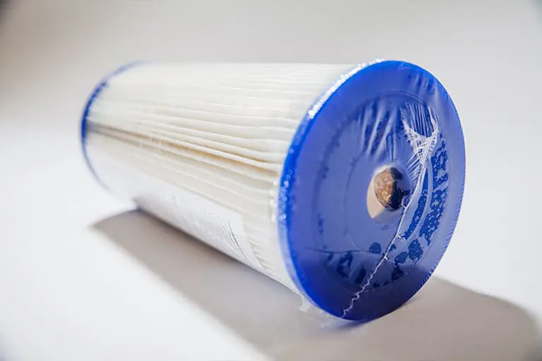 Blue and white cylindrical water filter cartridge.