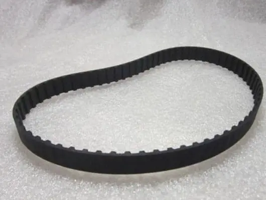 Black rubber timing belt on white surface.
