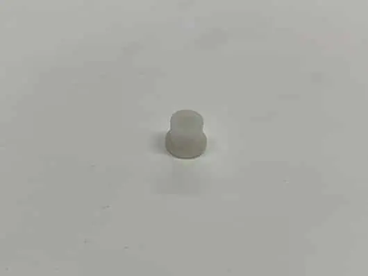 Small white cylindrical object on gray background.