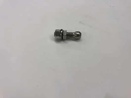 Metal bolt on a plain surface.