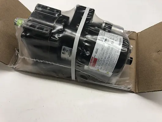 Packaged black motor in cardboard box.