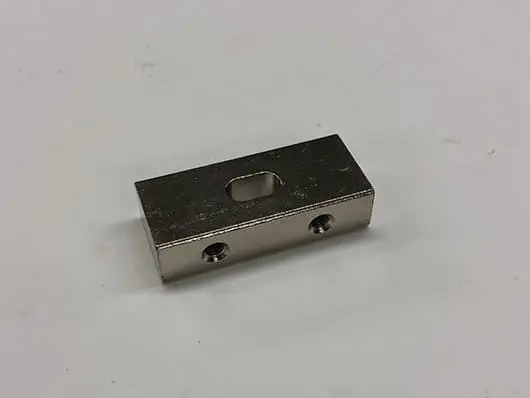 Rectangular metal block with two holes.