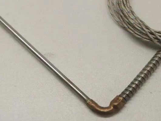 Metal rod and coiled wire on surface.