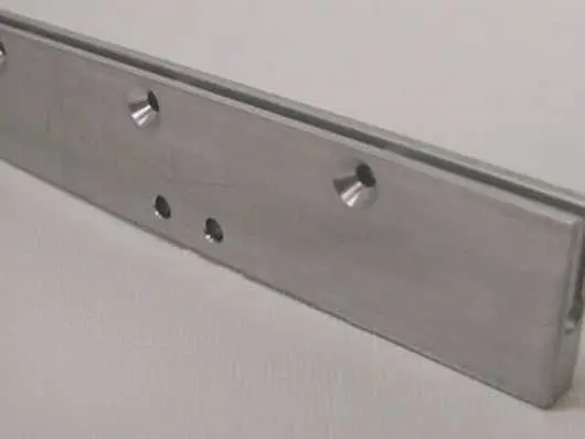 Metal bracket with multiple drilled holes.