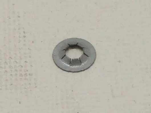 Metal washer on a textured surface.