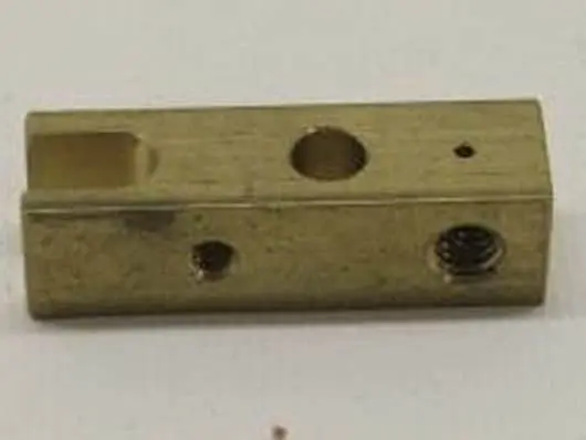 Rectangular metal block with various holes.