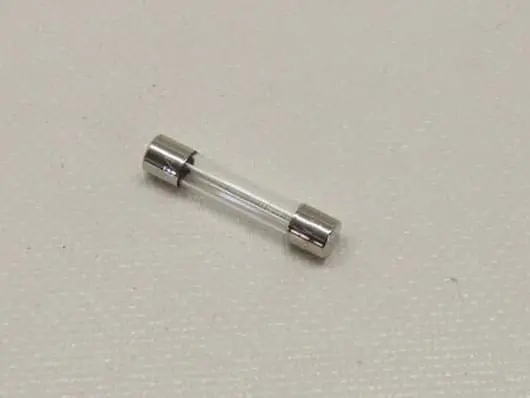 Glass tube fuse on textured surface.