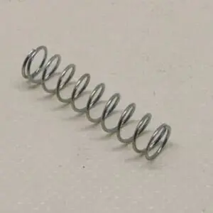 Metal coil spring on beige surface.