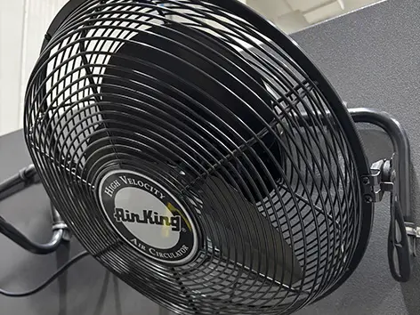 Black high-velocity wall-mounted fan.
