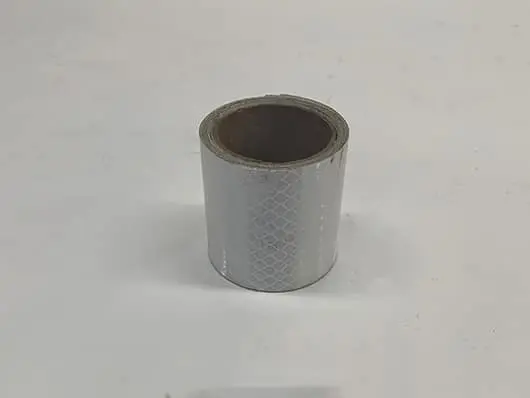 Roll of reflective adhesive tape on table.