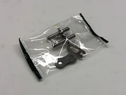 Here's a short alt tag for the image: Motorcycle chain repair kit parts.