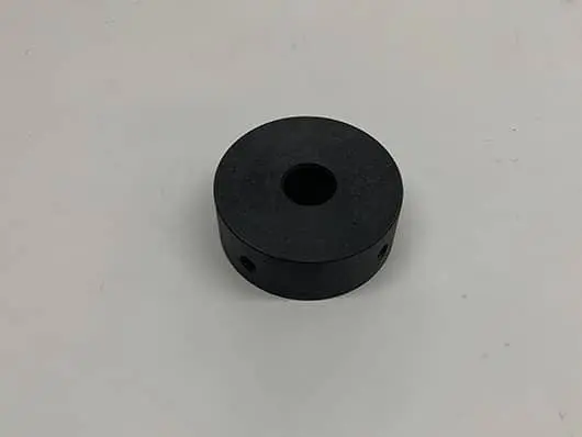 Black circular object on white background.