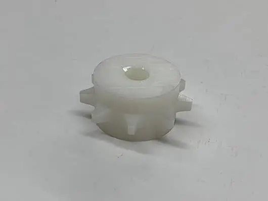 White plastic gear on gray background.