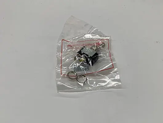 Toggle switch in clear plastic packaging.