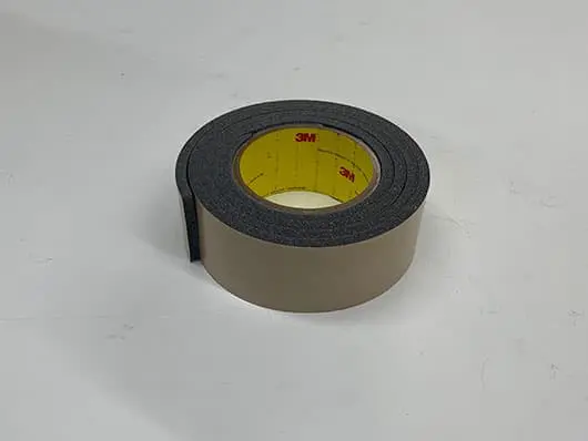 Roll of black adhesive tape on table.