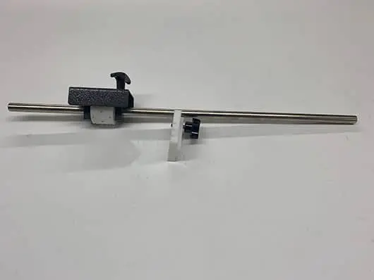 Metal rod with adjustable clamps on table.