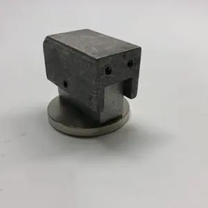 Metallic part on a round base.