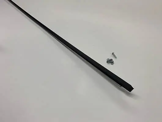 Black metal strip with screws on table.