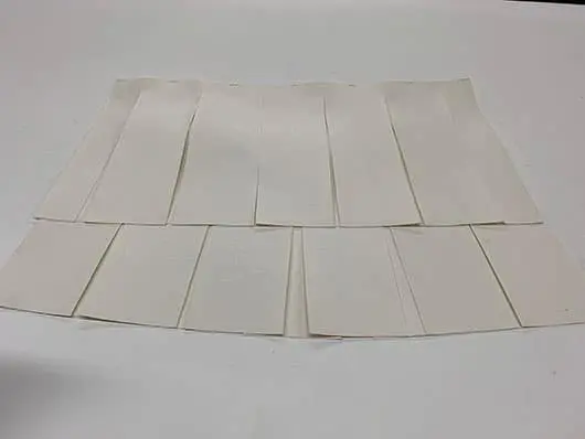 White paper strips arranged on flat surface.