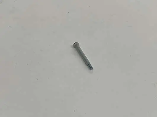 Single nail on a plain surface.