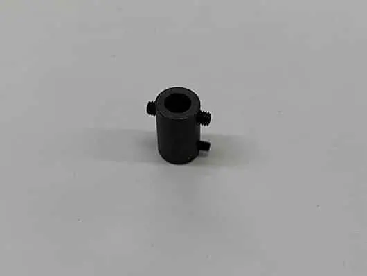 Black cylindrical part with three screws.