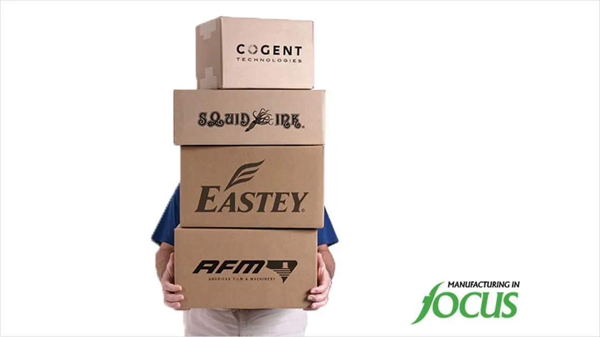 Person holding four stacked cardboard boxes.