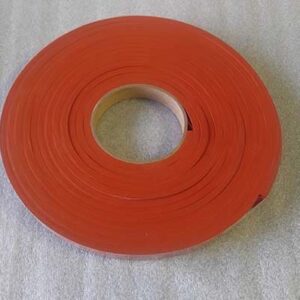 Red roll of tape on gray surface.