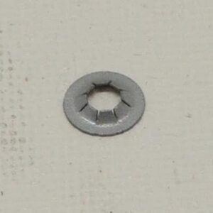 Metal washer on a textured surface.