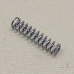 Metallic coil spring on textured surface.