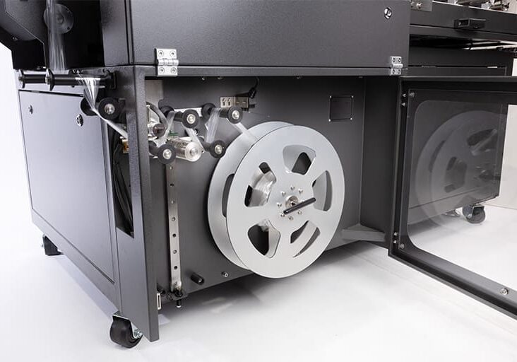 Industrial machine with large metal reel.